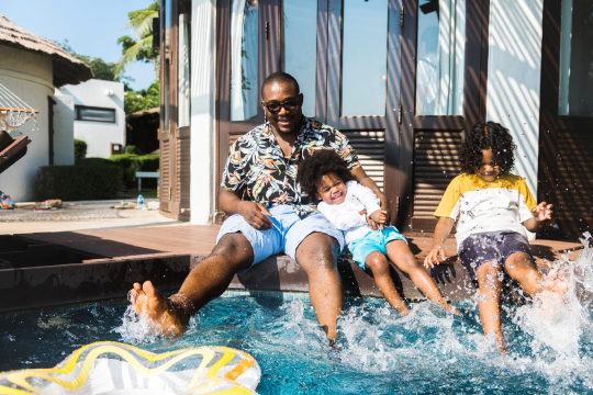 A happy family having fun in the pool at a villa, creating lasting memories together.


